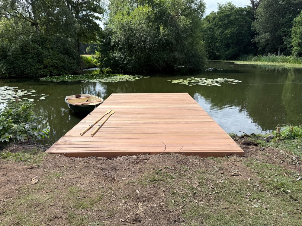 Completed timber jetty at private pond, featuring Yellow Balau decking and aluminum frame, blending naturally with the garden landscape.