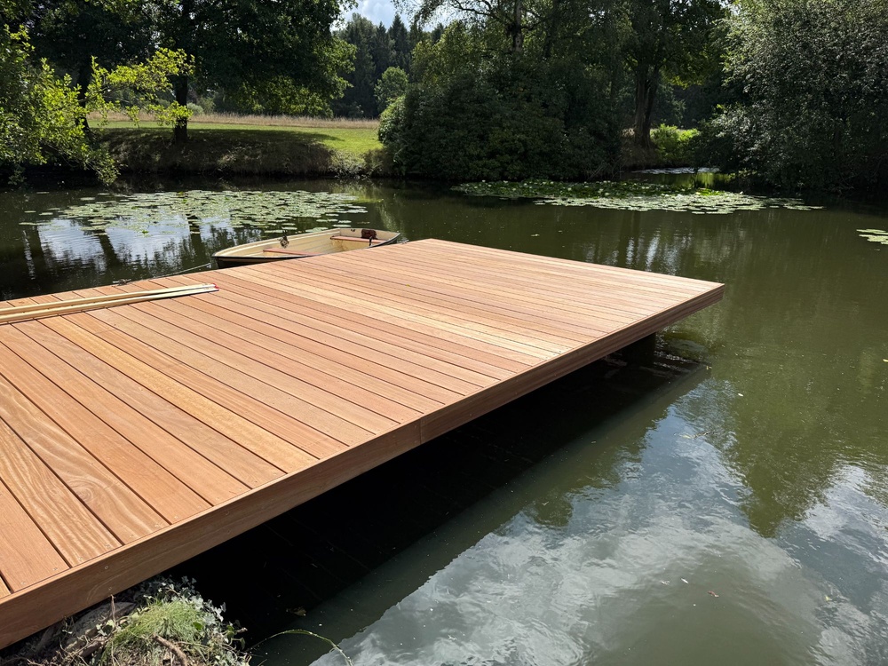 Elegant garden jetty extending 6.5 metres into a private pond, offering space for rowing boat access and relaxation.